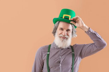 Bej arka planda yeşil şapkalı son sınıf öğrencisi. Aziz Patrick Günü kutlaması