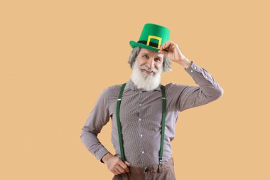 Bej arka planda yeşil şapkalı son sınıf öğrencisi. Aziz Patrick Günü kutlaması