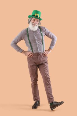 Bej arka planda yeşil şapkalı son sınıf öğrencisi. Aziz Patrick Günü kutlaması