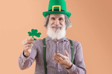 Yeşil şapkalı, yoncalı, bej arka planda son sınıf öğrencisi. Aziz Patrick Günü kutlaması