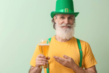 Yeşil şapkalı, arka planında bir bardak bira olan son sınıf öğrencisi. Aziz Patrick Günü kutlaması