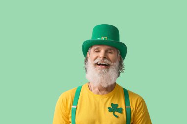 Yeşil arka planda şapkalı mutlu son sınıf öğrencisi. Aziz Patrick Günü kutlaması