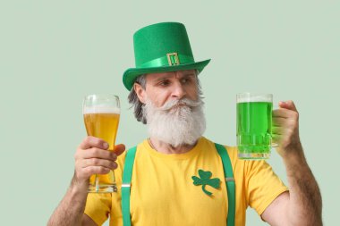 Hafif arka planda bira bardakları olan son sınıf öğrencisi. Aziz Patrick Günü kutlaması