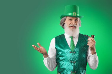 Yeşil arka planda tüttürme piposu olan son sınıf öğrencisi. Aziz Patrick Günü kutlaması