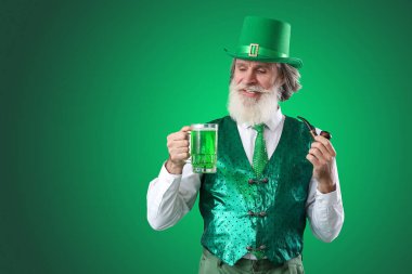 Yeşil arka planda sigara piposu ve bir bardak bira olan son sınıf öğrencisi. Aziz Patrick Günü kutlaması