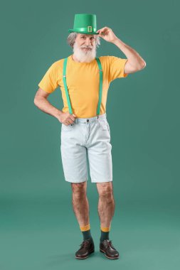 Yeşil arka planda şapkalı son sınıf öğrencisi. Aziz Patrick Günü kutlaması