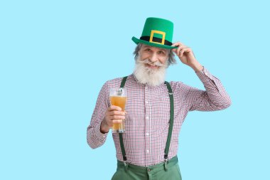 Mavi arka planda bir bardak birası olan son sınıf öğrencisi. Aziz Patrick Günü kutlaması