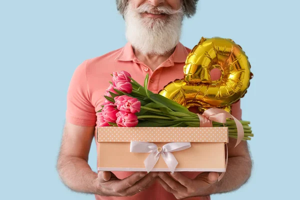 Elinde hediye kutusu, laleler ve balon olan son sınıf öğrencisi sekiz renk arka planda, yakın plan. Uluslararası Kadınlar Günü kutlamaları