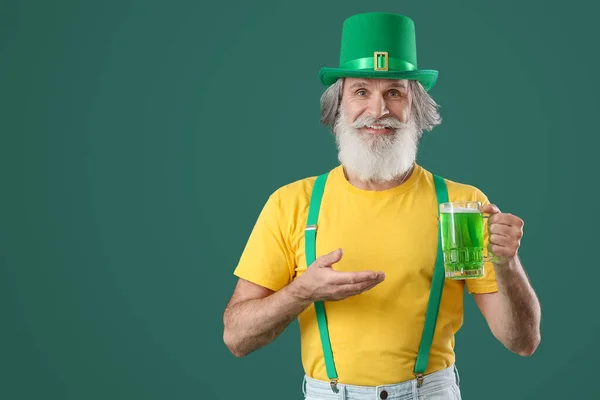 緑の背景にビールのグラスを持つシニア男 聖パトリックの日のお祝い — ストック写真