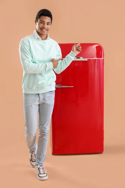 배경에 냉장고를 가리키는 아프리카 미국인의 미소짓는 — 스톡 사진