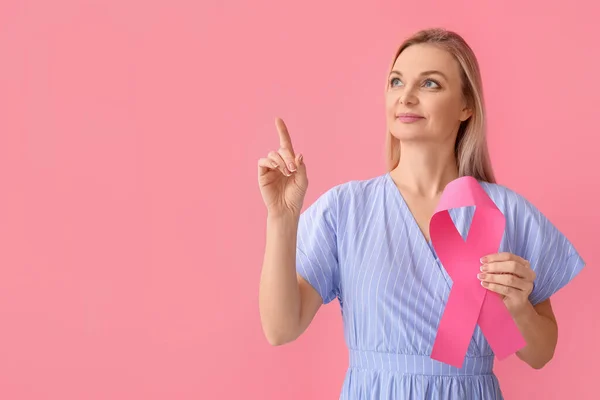 Woman Holding Pink Awareness Ribbon Pointing Something Color Background Breast — Stock Photo, Image