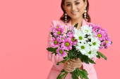 Krásná žena drží kytice květin na růžovém pozadí, detailní záběr. Mezinárodní den žen