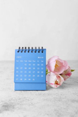 Uluslararası Kadınlar Günü kutlamaları için takvim ve çiçekler açık arkaplanda