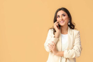 Renkli arka planda telefonla konuşan şık aksesuarları olan bir kadın. Uluslararası Kadınlar Günü