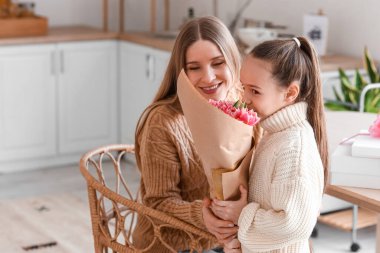 Küçük kız Uluslararası Kadınlar Günü 'nde annesini bir buket laleyle selamlıyor.