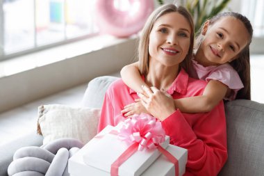 Uluslararası Kadınlar Günü 'nde annesine hediyeyle sarılan küçük bir kız.