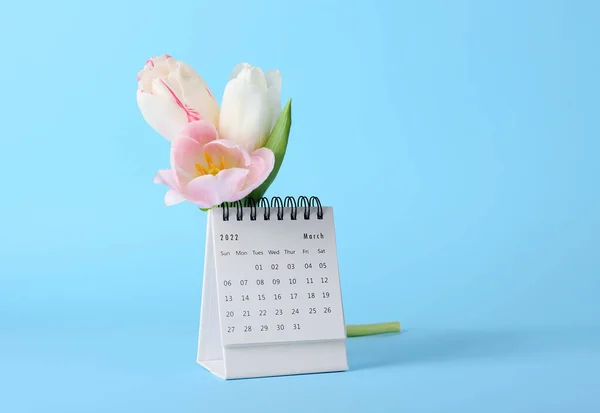 蓝色背景下的国际妇女节庆祝活动日历和花朵 — 图库照片