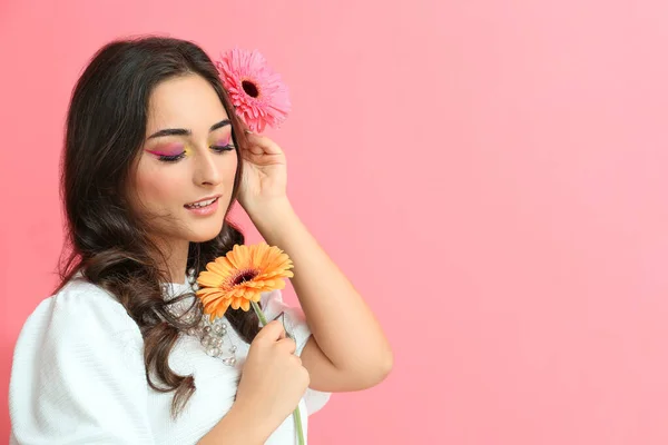 Vacker Kvinna Med Kreativ Makeup Och Gerbera Blommor Rosa Bakgrund — Stockfoto