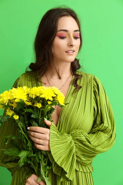 Женщина Креативным Макияжем Держит Букет Цветов Смотрит Вниз Зеленый Фон — стоковое фото