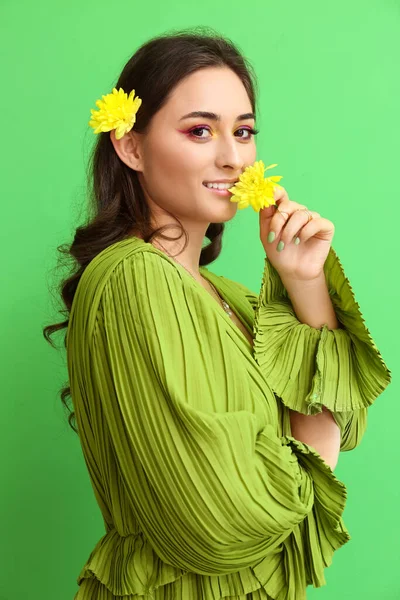 緑の背景に創造的なメイクや菊の花を持つ若い女性 国際女性デー — ストック写真