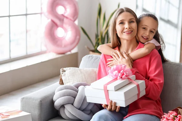 Uluslararası Kadınlar Günü 'nde annesine hediyeyle sarılan küçük bir kız.