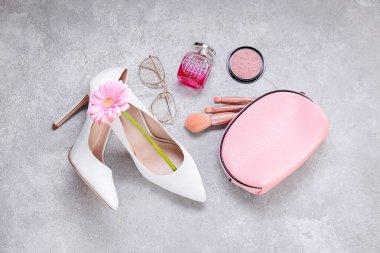 Kozmetik çantalı kompozisyon, fırçalar, parfüm şişesi ve Gri arka planda Uluslararası Kadınlar Günü kutlamaları için kadın aksesuarları