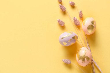 Renkli arka planda güzel Paskalya yumurtaları ve kurutulmuş çiçekler