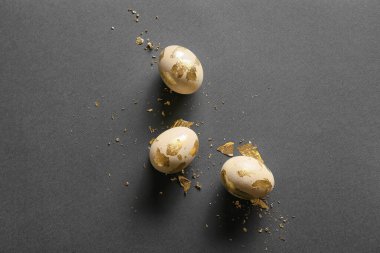 Güzel Paskalya yumurtaları ve koyu arkaplanda altın folyo