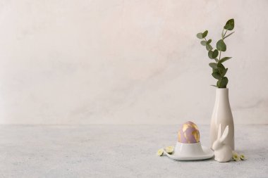 Paskalya yumurtası ve okaliptüs dalları olan güzel bir tutucu.