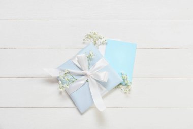 Güzel bir hediye, boş bir kart ve açık ahşap arka planda çiçekler. Uluslararası Kadınlar Günü kutlamaları