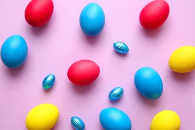 Renkli arka planda farklı boyanmış Paskalya yumurtaları
