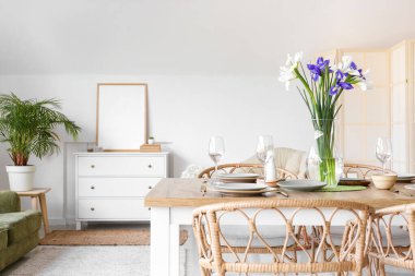 Uluslararası Kadınlar Günü kutlamaları için yemek masasının üzerinde süsen çiçekleri olan güzel bir ortam ve vazo.