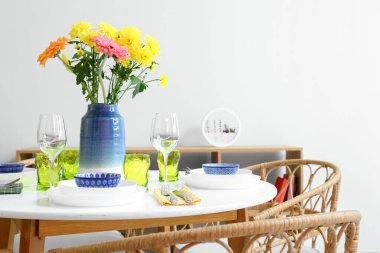 Güzel çiçekli yemek masası ve aydınlık duvarın yanında Uluslararası Kadınlar Günü kutlaması.