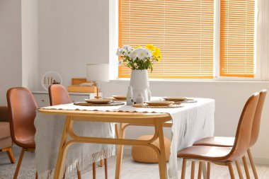 Uluslararası Kadınlar Günü kutlamaları için yemek masasında kasımpatı çiçekli vazo.