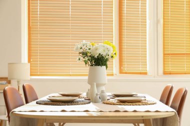 Kasımpatı çiçekli yemek masası ve Uluslararası Kadınlar Günü kutlamaları için aydınlık odada şık bir ortam.