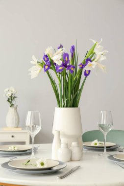 Uluslararası Kadınlar Günü kutlamalarında servis edilen süsen çiçekli vazo ve yemek masası.