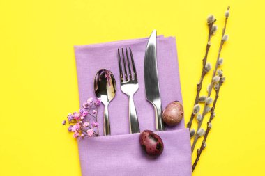 Sarı arka planda Paskalya kutlaması için güzel çatal bıçak takımı.