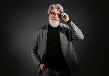 Esmer arka planda yakışıklı, olgun sakallı iş adamı portresi.