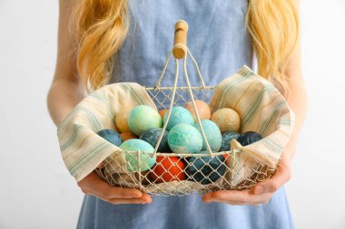 Paskalya yumurtalarıyla dolu sepeti olan bir kadın.
