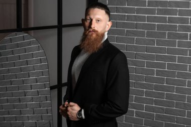 Karanlık odadaki yakışıklı sakallı adamın portresi.