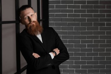 Karanlık odadaki yakışıklı sakallı adamın portresi.