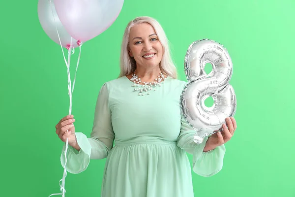 Uśmiechnięta Dojrzała Kobieta Trzymająca Balony Zielonym Tle Międzynarodowy Dzień Kobiet — Zdjęcie stockowe