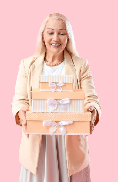 Femme Mature Tenant Pile Boîtes Cadeaux Sur Fond Rose Célébration — Photo