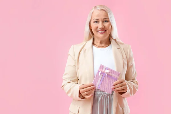 Lächelnde Reife Frau Mit Geschenkbox Auf Rosa Hintergrund Feier Zum — Stockfoto