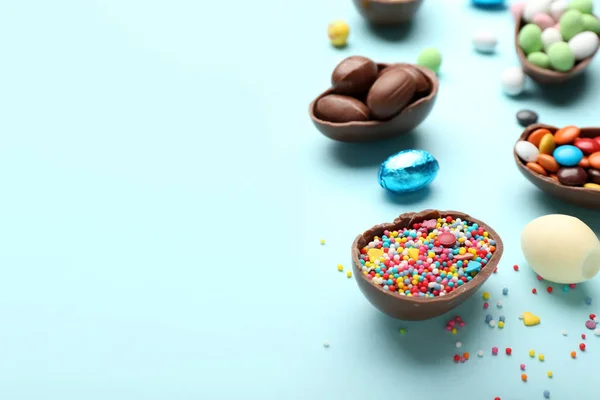 チョコレートイースターの卵と組成物 青の背景にキャンディーやスプリンクル クローズアップ — ストック写真