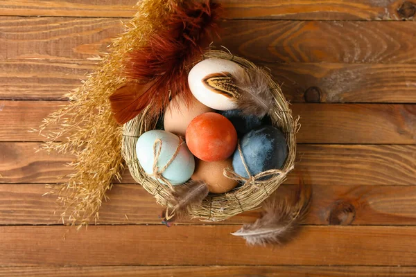 Ninho Com Ovos Páscoa Multicoloridos Penas Espiguetas Fundo Madeira — Fotografia de Stock