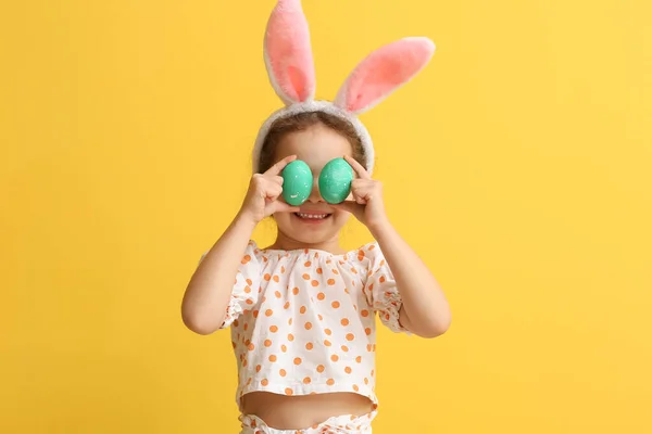 Lustiges Kleines Mädchen Mit Hasenohren Und Ostereiern Auf Gelbem Hintergrund — Stockfoto