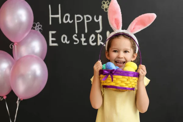 可爱的小女孩 长着小兔子耳朵 背景是漆黑的复活节篮子 — 图库照片