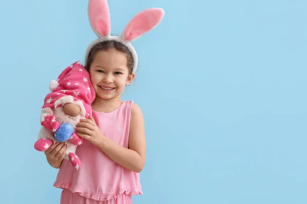 青い背景にウサギの耳とおもちゃを持つ面白い女の子 イースターのお祝い — ストック写真