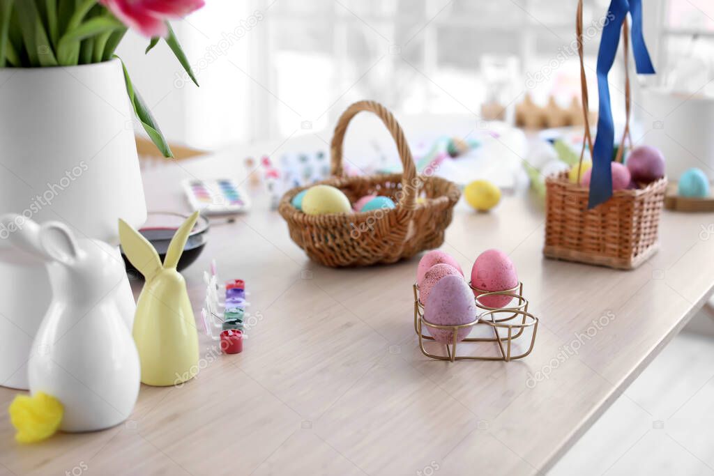 Colorful Easter eggs with paints on table in kitchen